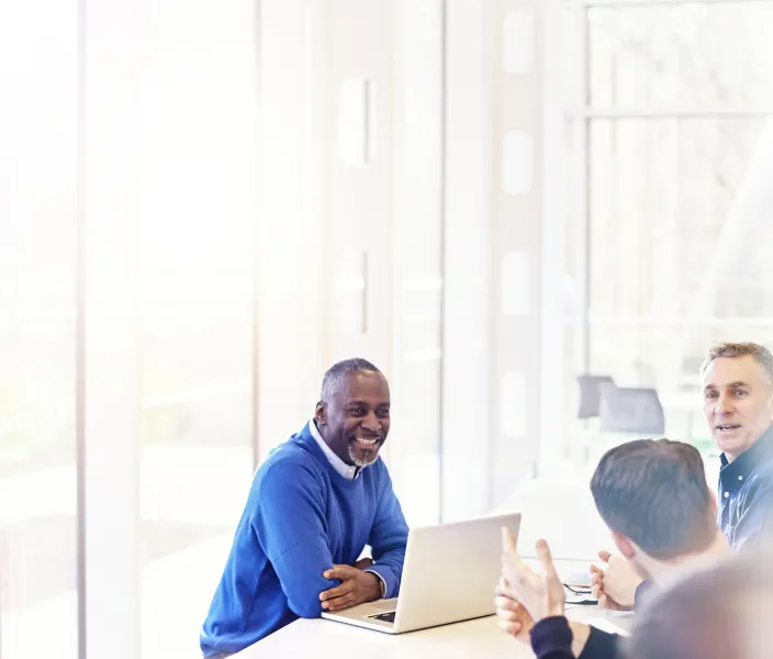 An employee smiles at a colleague in a meeting