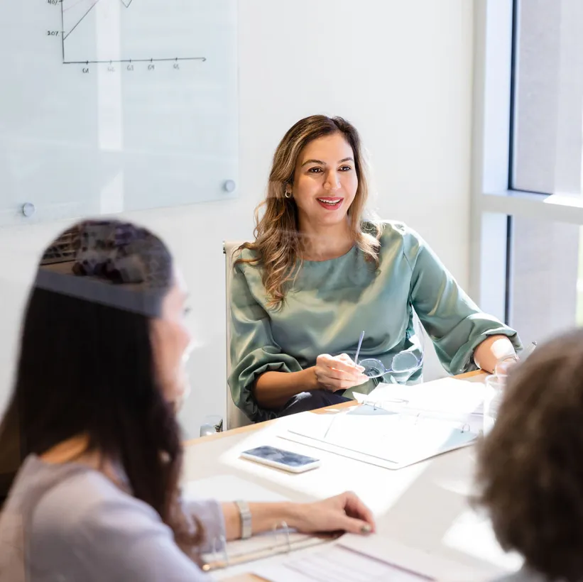 A female employee smiles in discussion with colleagues