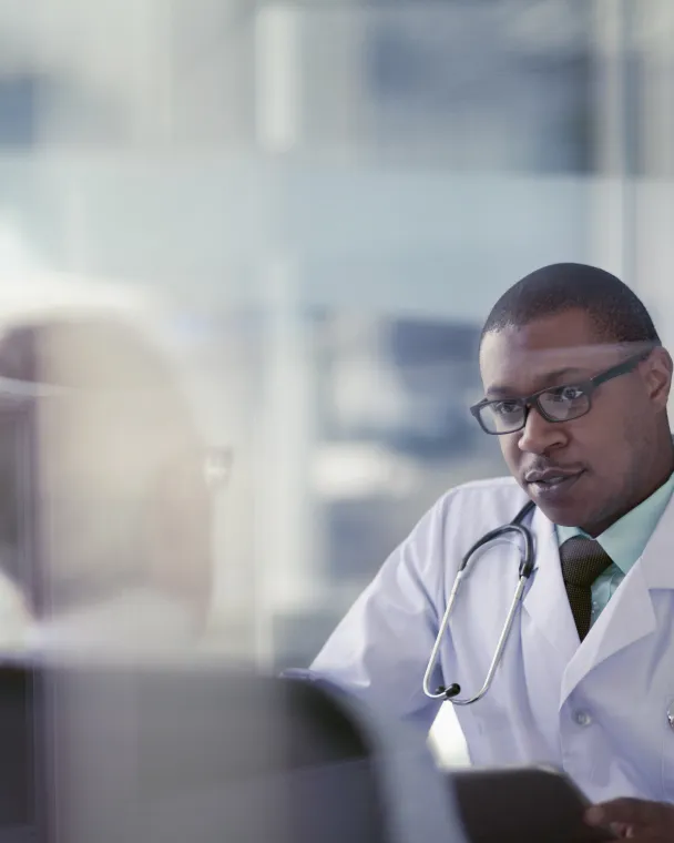 A male doctor talks with a patient in a meeting room