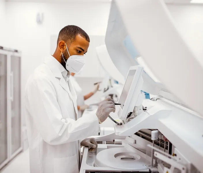 A masked scientist works over his experiment station